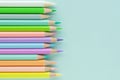 Pastel multi-colored pencils on empty pale blue sheet of paper Royalty Free Stock Photo