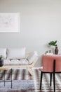 Pink armchair and beige scandinavian futon in trendy living room interior with black and white floor Royalty Free Stock Photo