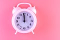 Pastel pink clock on pink painted wall. Minimal time concept. Chrismas eve or new year idea