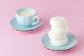 Pastel pink horizontal banner with copy space - white zephyr dessert on blue plate and cup of coffee with milk.