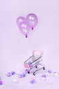 Pastel pink shopping cart floating with balloon on pink background