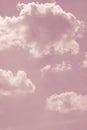 Pastel pink sky with white fluffy clouds