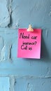 Pastel Pink Sticky Note on Textured Blue Wall with Car Insurance Advertisement, Copy Space Royalty Free Stock Photo