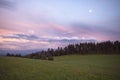 Pastel pink sunset cloudscape over the Jura mountains. Beautiful evening sky landscape over the meadows and forest. Royalty Free Stock Photo