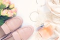 Pastel pink women shoes, perfume and roses on white background. Pair of elegant and stylish loafers. Flat lay, top view