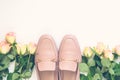 Pastel pink women shoes and roses on white background. Pair of elegant and stylish loafers. Flat lay, top view trendy