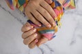 Pastel softness colorful manicured nails. Woman showing her new summer manicure in colors of pastel palette. Simplicity