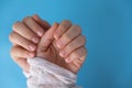 Pastel softness manicured nails on blue background. Woman showing her new manicure in colors of pastel palette