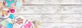 Pastel summer sweets corner border over a rustic white wood banner background