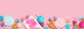 Pastel sweets bottom border. Top view over a pink banner background. Royalty Free Stock Photo