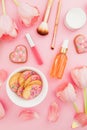 Pastel tulips flowers and cosmetics, cookies on pink background. Flat lay, top view.