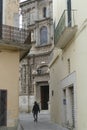 Pastel walls on narrow street with ornate doors and balconies