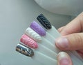 Pastel winter designs on the tips. Stylish drawings on manicure tips similar to a knitted sweater on the background of the desktop