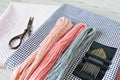 Pastel wool embroidery threads, needles, cotton fabric and retro scissors