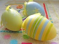Close up of pastel yellow, blue and green easter eggs on embroidery canvas