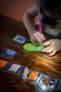 Pasting gemstones, a little girl is making artwork with her own hands