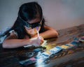 Pasting gemstones, a little girl is making artwork with her own hands