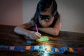 Pasting gemstones, a little girl is making artwork with her own hands