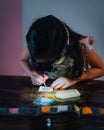 Pasting gemstones, a little girl is making artwork with her own hands