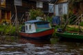 PASTO, COLOMBIA - JULY 3, 2016: colorfull boat parked next to a green canoe infront of some houses in la cocha lake Royalty Free Stock Photo