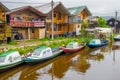 PASTO, COLOMBIA - JULY 3, 2016: some colorfull boats parked on the river next to some shops