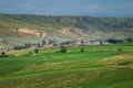 Pastoral village in valley with farm field on foreground Royalty Free Stock Photo