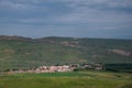 Pastoral village in valley with farm field on foreground Royalty Free Stock Photo