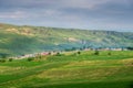 Pastoral village in valley with farm field on foreground Royalty Free Stock Photo