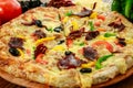 Pastrami and eggs pizza pie with bell pepper, tomato and black olive served in wooden board isolated on table side view of arabic Royalty Free Stock Photo