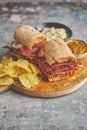 Pastrami sandwhich with delicious meet on baguette bread with chedder cheese, onion