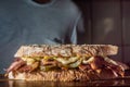 Pastrami sandwhich on a wooden tablet with delicious meet on baguette bread with cheese,copy space in parts of the image Royalty Free Stock Photo