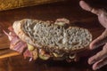 Pastrami sandwhich on a wooden tablet with delicious meet on baguette bread with cheese,copy space in parts of the image