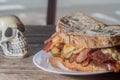 Pastrami sandwhich on a wooden tablet with delicious meet on baguette bread with cheese,copy space in parts of the image Royalty Free Stock Photo