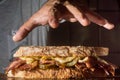 Pastrami sandwhich on a wooden tablet with delicious meet on baguette bread with cheese,copy space in parts of the image Royalty Free Stock Photo