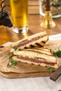 Pastrami sandwich on grilled bread with pickles and mustard on wooden table Royalty Free Stock Photo