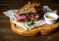 Pastrami sandwich on wooden plate Royalty Free Stock Photo