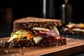 pastrami and swiss cheese sandwich on dark rye bread, shot from the side Royalty Free Stock Photo