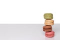 Pastries, desserts and sweets. Close-up on a heap of four colorful macaron cookies on bright table isolated on a white background