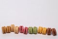 Pastries, desserts and sweets.  Close-up of multicolord original french macaroon cookies are arranged in a row on a sparkling Royalty Free Stock Photo