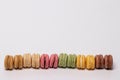 Pastries, desserts and sweets.  Close-up of multicolord original french macaroon cookies are arranged in a row on a sparkling Royalty Free Stock Photo