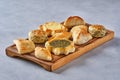 Pastries, fatayer or samosa, manaqeesh with zaatar and cheese . Assorted pasties with spinach and potato on wooden board