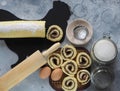 Pastry background.Homemade roll with plum jam, sprinkled with powdered sugar, on a black chopping Board in the shape of a rooster