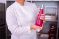 Female chef holding pastry bag with pink meringue cooking dessert