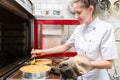 Pastry baker putting pies or cakes in oven