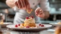 A pastry chef arranging edible flowers on a stunning wedding cake Royalty Free Stock Photo