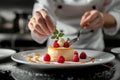 A pastry chef arranging edible flowers on a stunning wedding cake Royalty Free Stock Photo