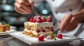 A pastry chef arranging edible flowers on a stunning wedding cake Royalty Free Stock Photo