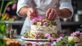A pastry chef arranging edible flowers on a stunning wedding cake Royalty Free Stock Photo