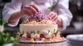 A pastry chef arranging edible flowers on a stunning wedding cake Royalty Free Stock Photo