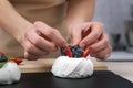 Pastry chef decorates cake with fresh strawberries and blueberries. Cake Anna Pavlova Royalty Free Stock Photo